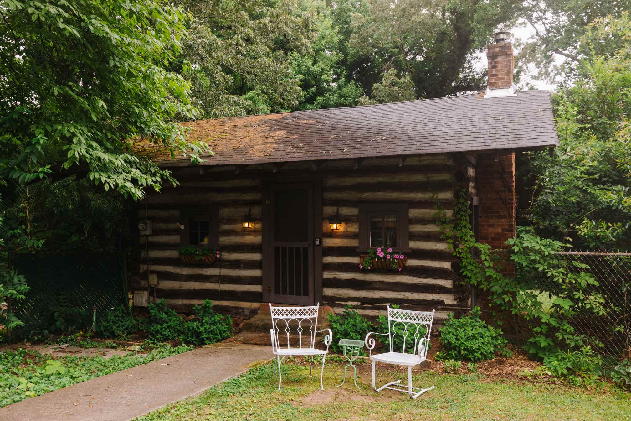 The Cabin Greenville log cabin exterior with flower boxes and lanterns
