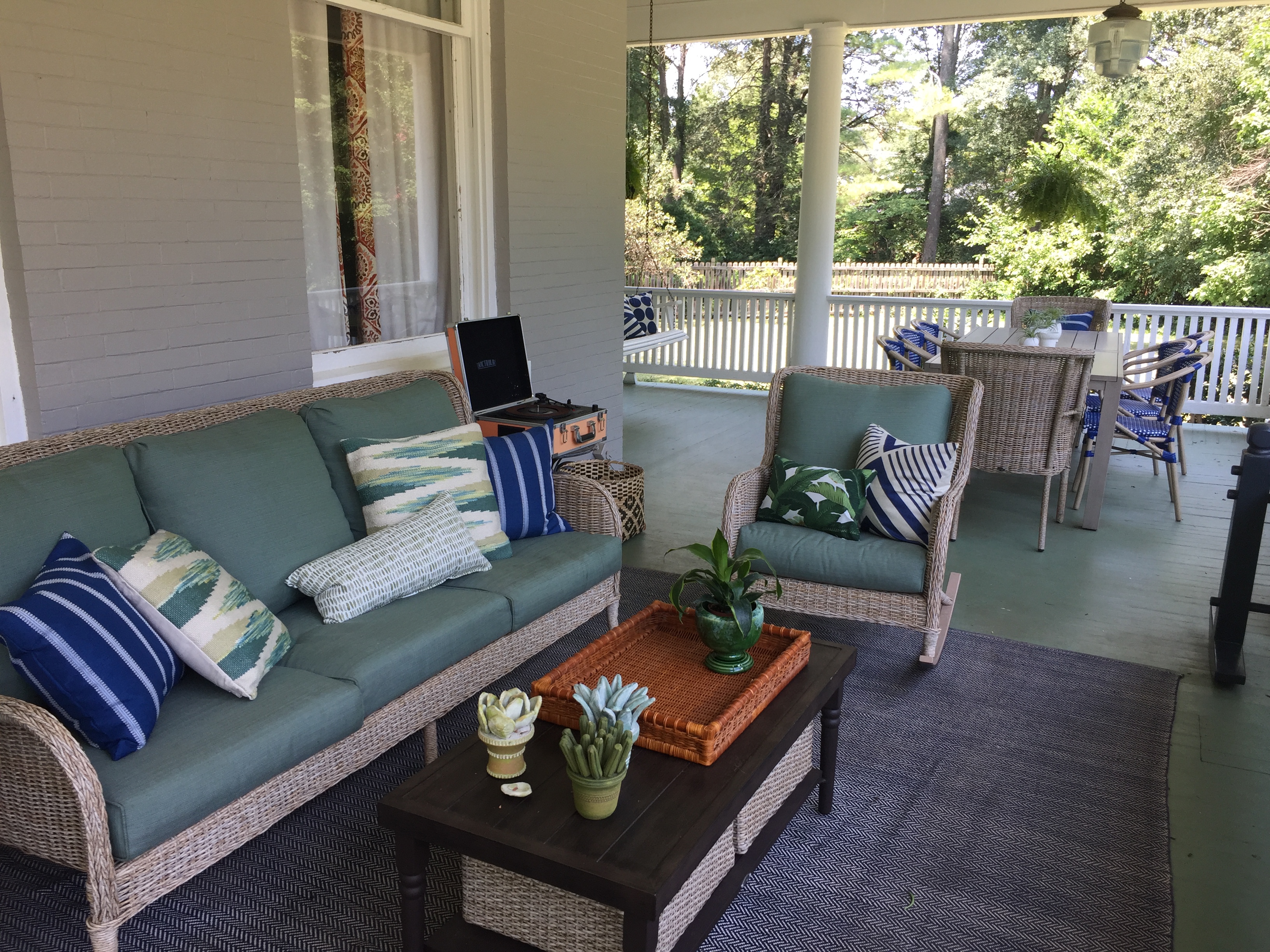 Spacious wraparound porch with wicker furniture at The Franklin House